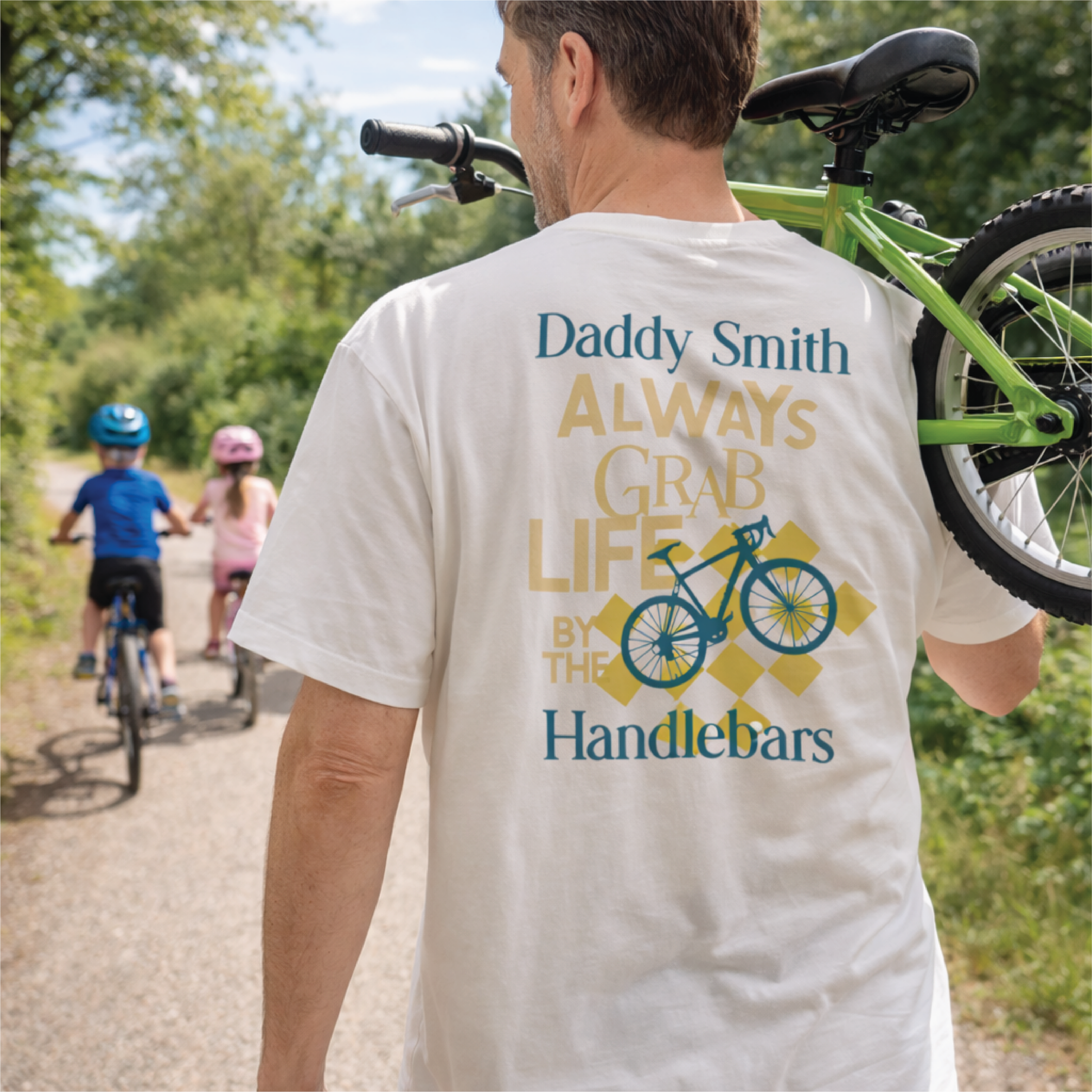 Man wearing a 'Daddy Smith' t-shirt with a bicycle graphic and text, standing outdoors with children on bikes in the background.