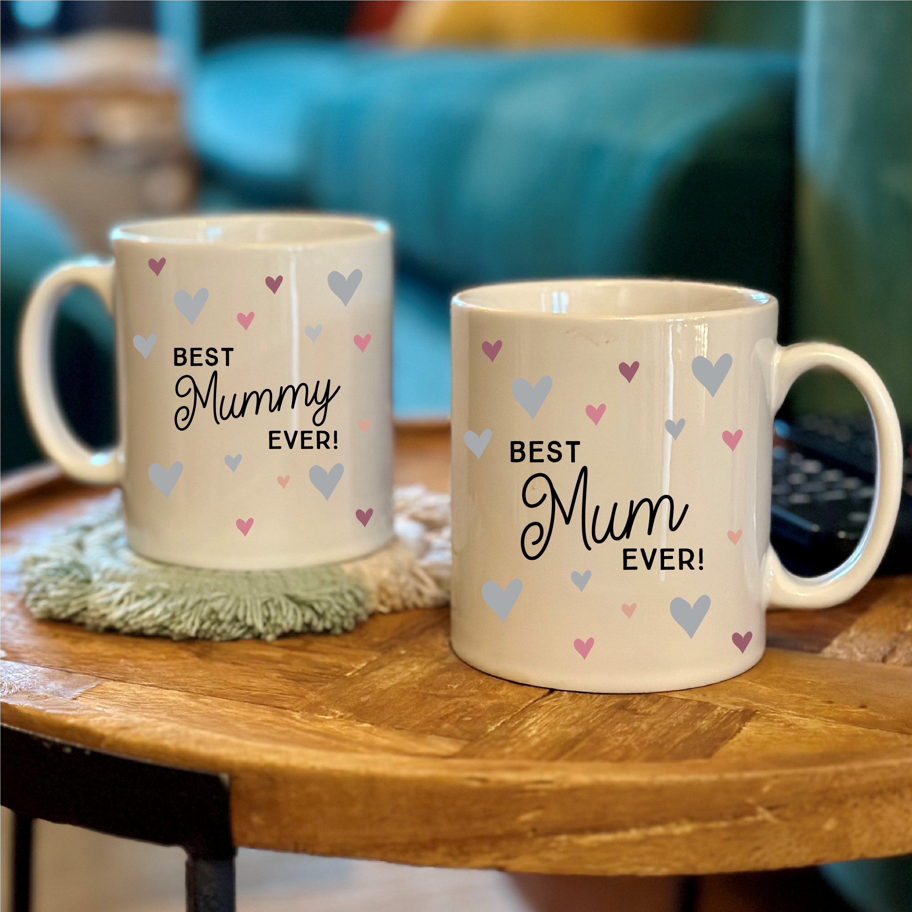 Two mugs with 'Best Grandma Ever!' and 'Best Nanny Ever!' text on a wooden table.