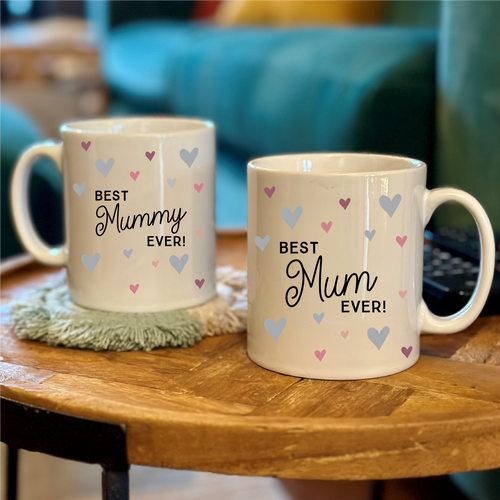 Two mugs with 'Best Grandma Ever!' and 'Best Nanny Ever!' text on a wooden table.