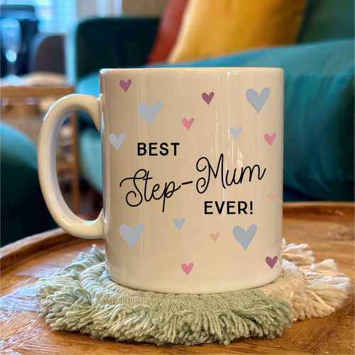 Mug with 'Best Step-Mum Ever!' text on a wooden table with a cozy background