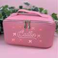 Pink cosmetic bag with 'Caitlin' and bow designs on a pink background