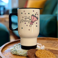 White travel mug with 'Best Mummy' and an umbrella design on a wooden table.