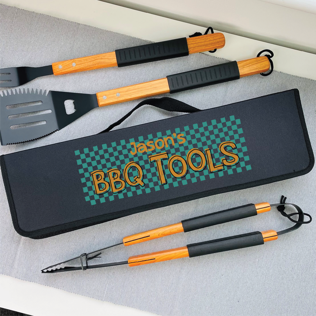 Set of BBQ tools with a personalized case on a gray surface