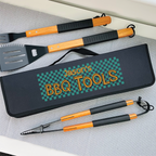 Set of BBQ tools with a personalized case on a gray surface