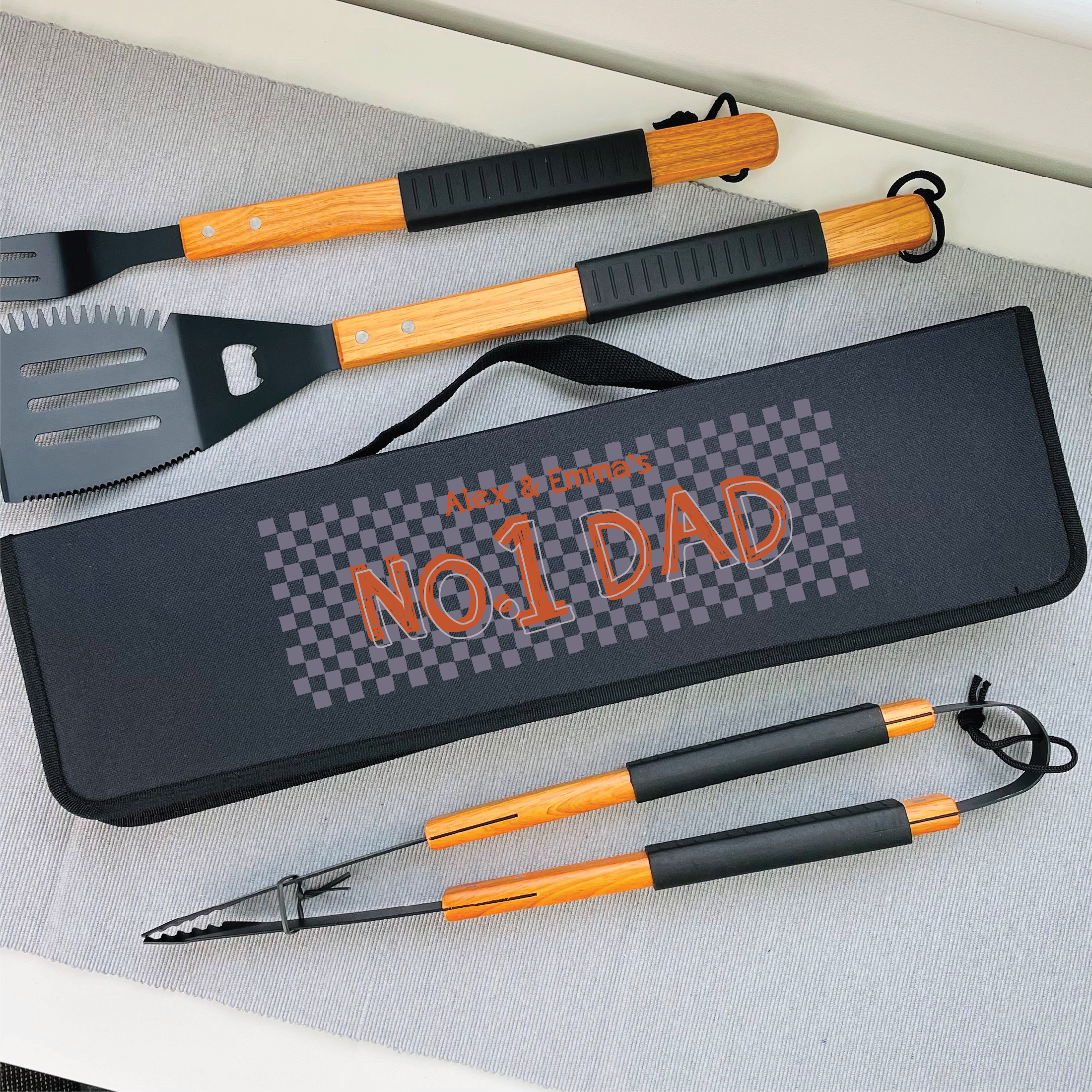 Barbecue tool set with 'No. 1 Dad' case on a gray surface