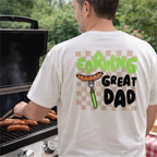 Man grilling outdoors wearing a t-shirt with 'Forking Great Dad' text and graphic.