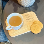 Cup of tea and cookies on a wooden board with 'Daddy's Golf Snacks' engraving.