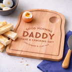 Wooden cutting board with engraved message on a breakfast setting