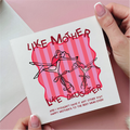 Card with 'Like Mother, Like Daughter' design held by a hand on a pink background