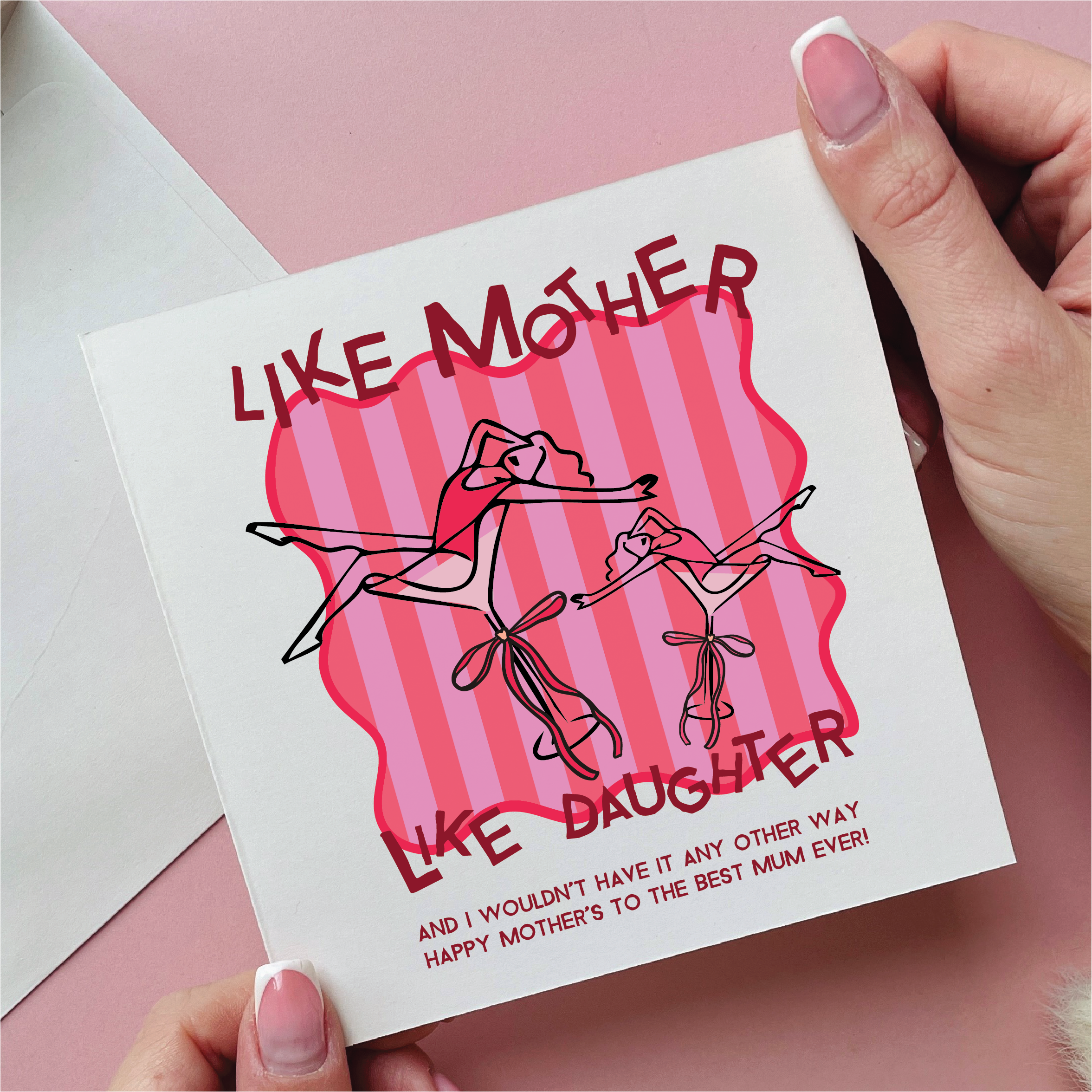 Card with 'Like Mother, Like Daughter' design held by a hand on a pink background
