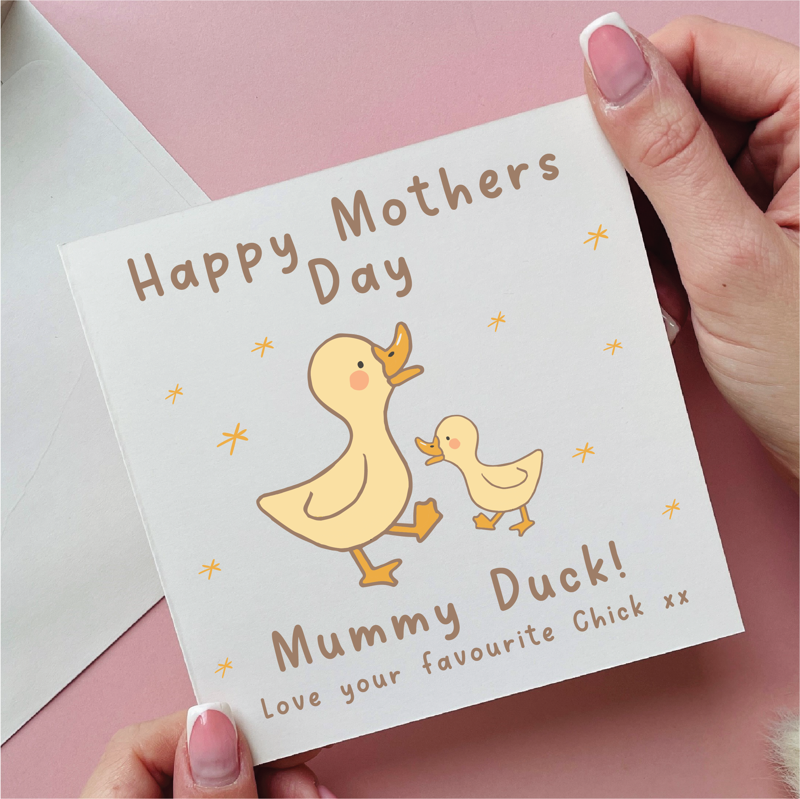 Card with 'Happy Mother's Day' and 'Mummy Duck!' text, held by a hand on a pink background.