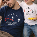 Man and child wearing matching t-shirts with fuel gauge design in a living room.