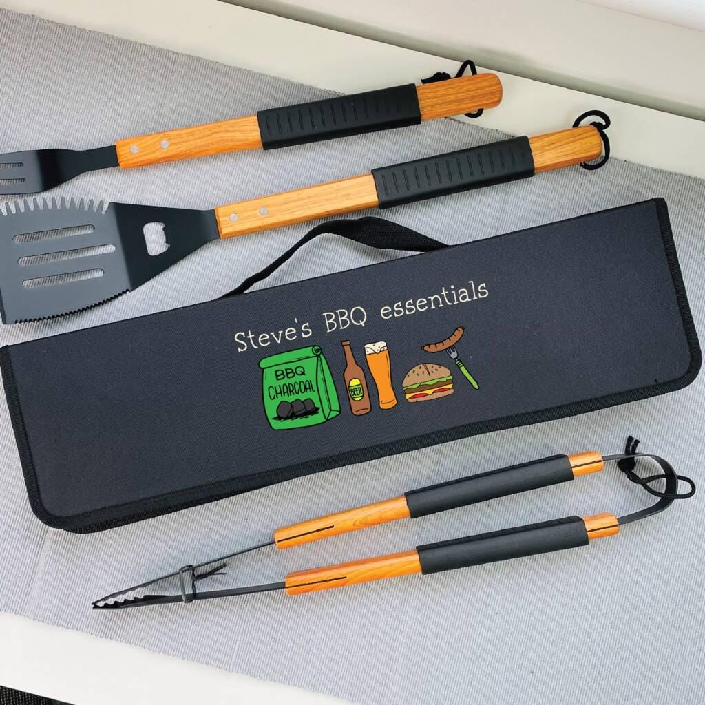 Set of BBQ utensils with a carrying case labeled 'Steve's BBQ essentials' on a gray surface.