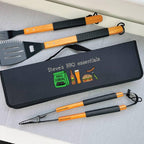 Set of BBQ utensils with a carrying case labeled 'Steve's BBQ essentials' on a gray surface.
