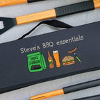 Set of BBQ utensils with a personalized carrying case on a gray surface