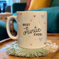 Mug with 'Best Auntie Ever!' text on a wooden table with a blurred background