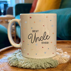 Mug with 'Best Uncle Ever!' text on a wooden table with a cozy background