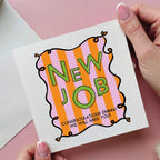 Hand holding a 'New Job' card with colorful design on a pink background