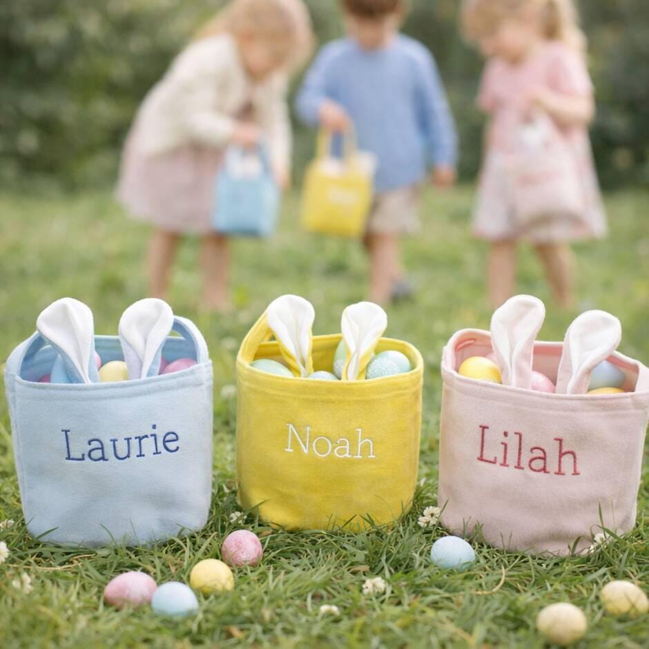 Three personalized Easter baskets with bunny ears on a grassy field, with children in the background.