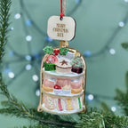 Decorative Christmas ornament with a cake design and 'Merry Christmas Alex' tag, hanging on a tree.