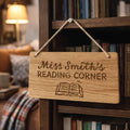 Wooden sign reading 'Miss Smith's Reading Corner' hanging on a bookshelf.