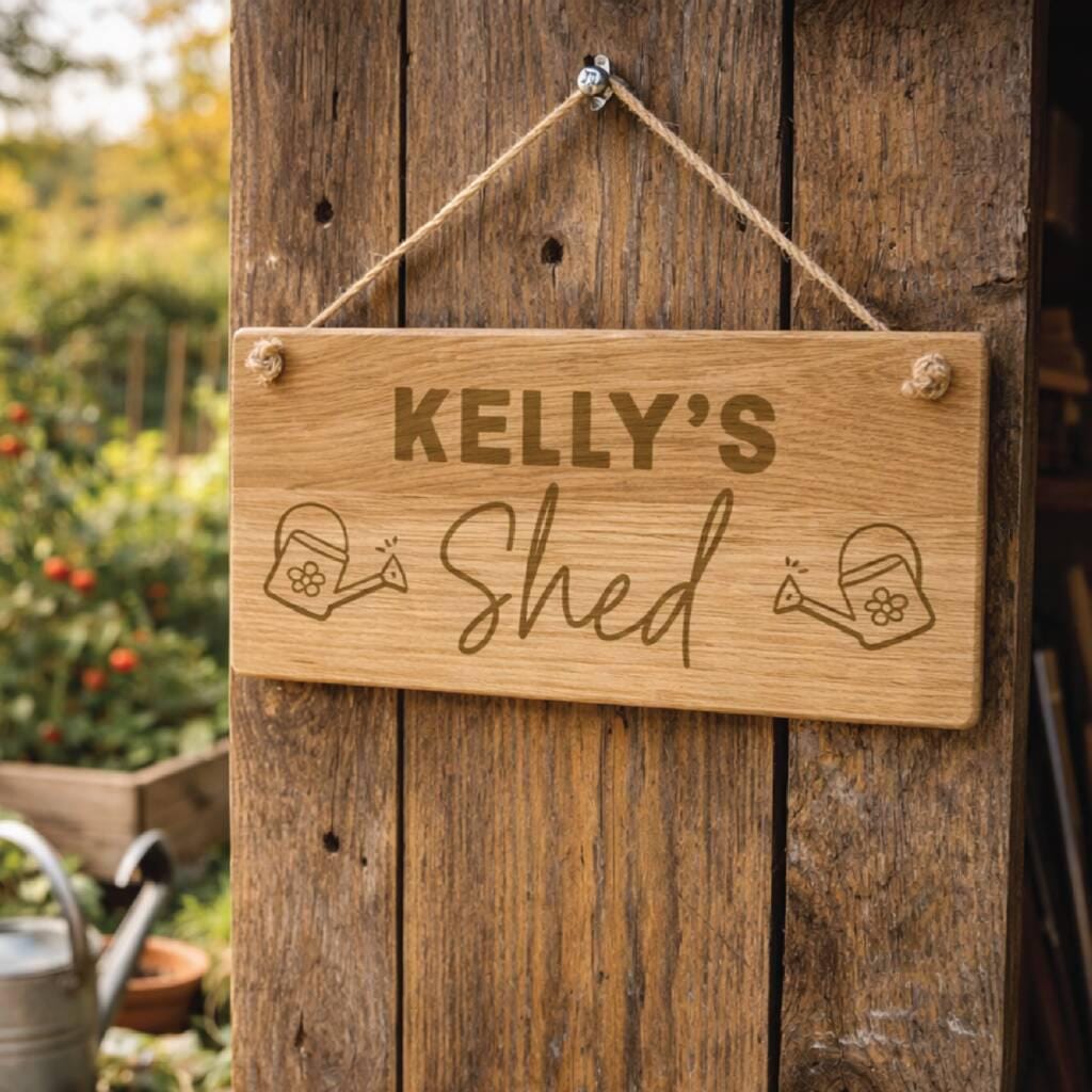 Wooden sign with 'KELLY'S Shed' on a wooden door with garden elements in the background.