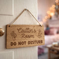 Wooden sign on a door with 'Caitlin's Room DO NOT DISTURB' text
