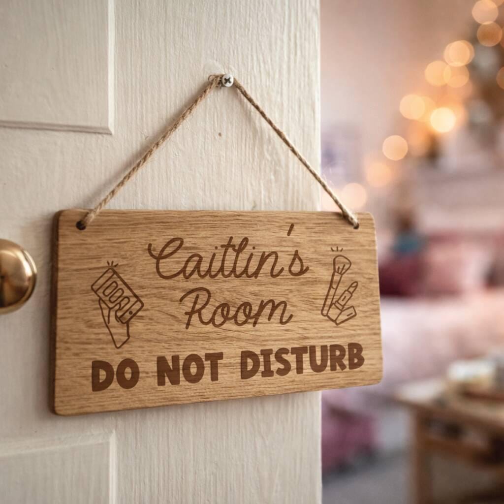 Wooden sign on a door with 'Caitlin's Room DO NOT DISTURB' text