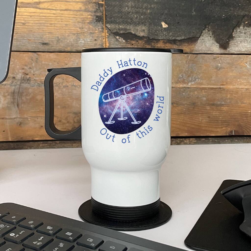 White travel mug with a design and text on a wooden surface