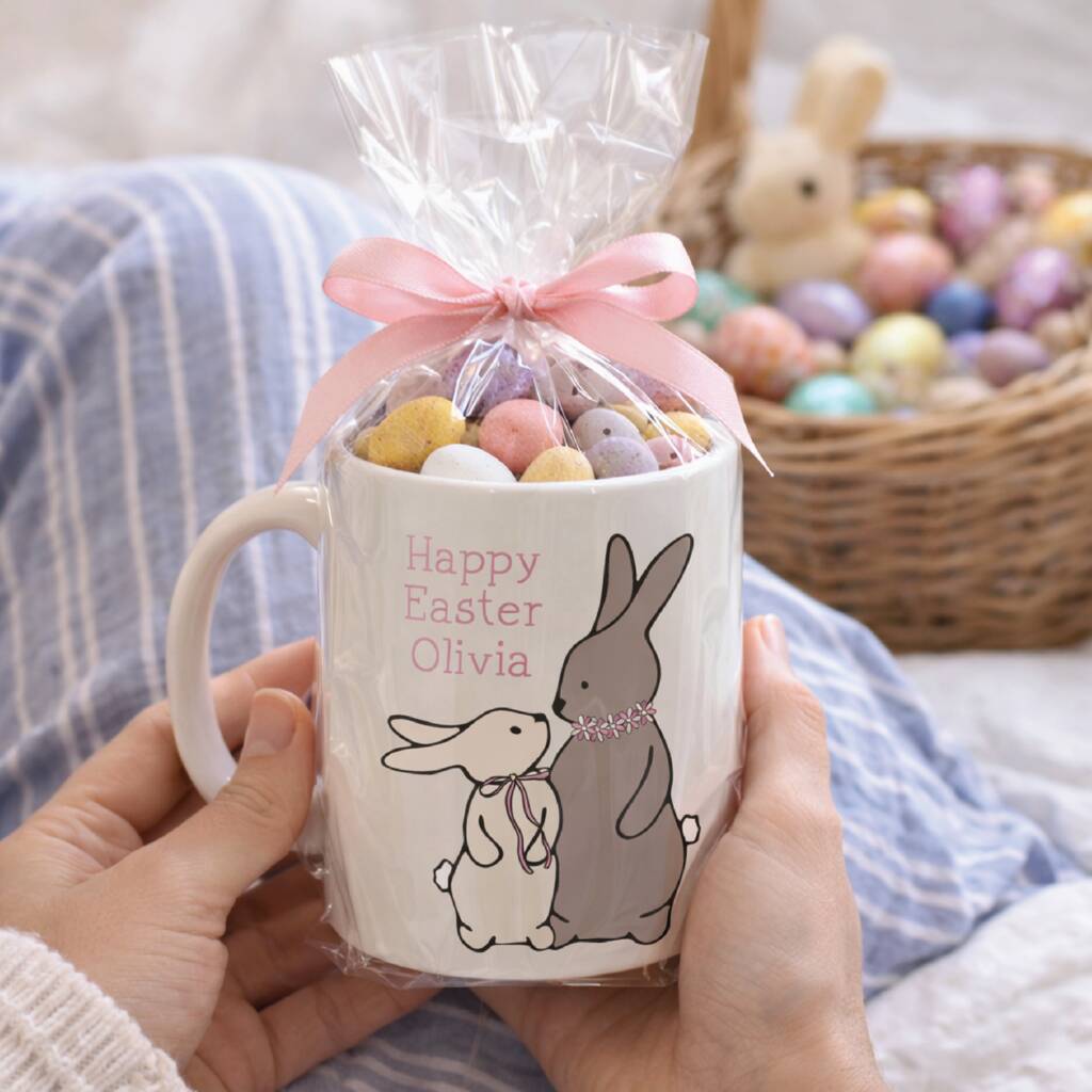 Person holding a 'Happy Easter Olivia' mug with a bag of candy and a bunny rabbit design.