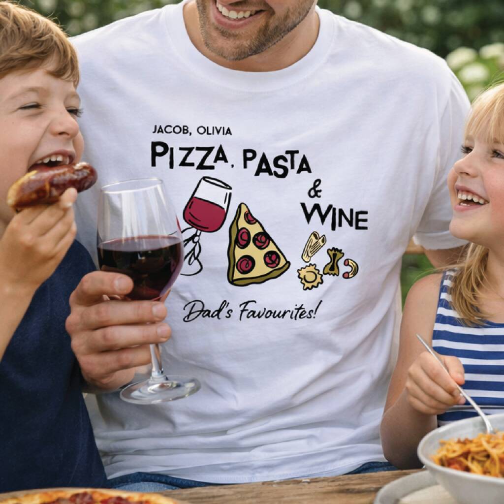 Man wearing a t-shirt with pizza, pasta, and wine design, holding a glass of red wine, surrounded by two children eating.